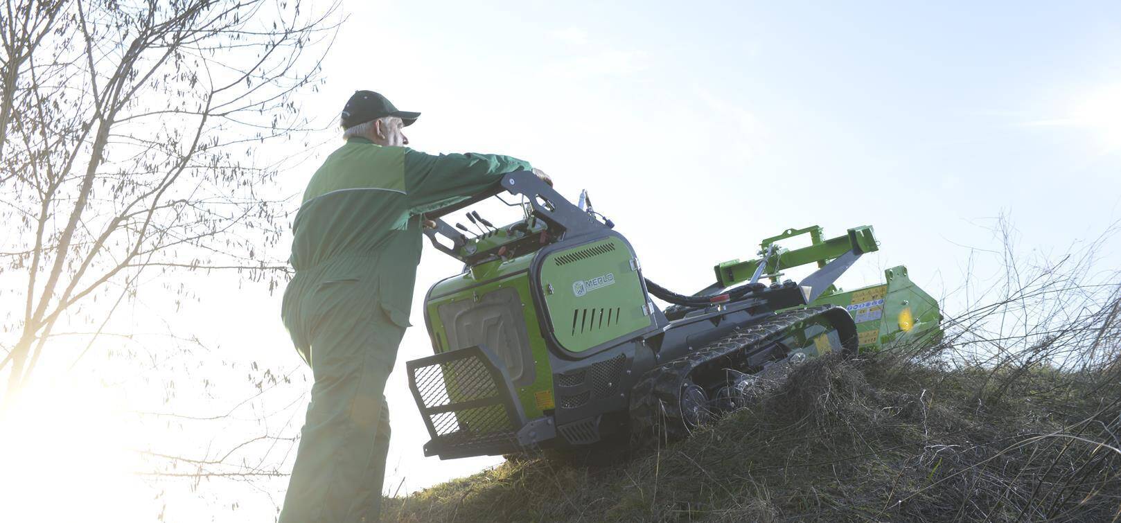 Werknemer gebruikt een Merlo Cingo 8.3EVO rupsdumper met klepelmaaier op helling.