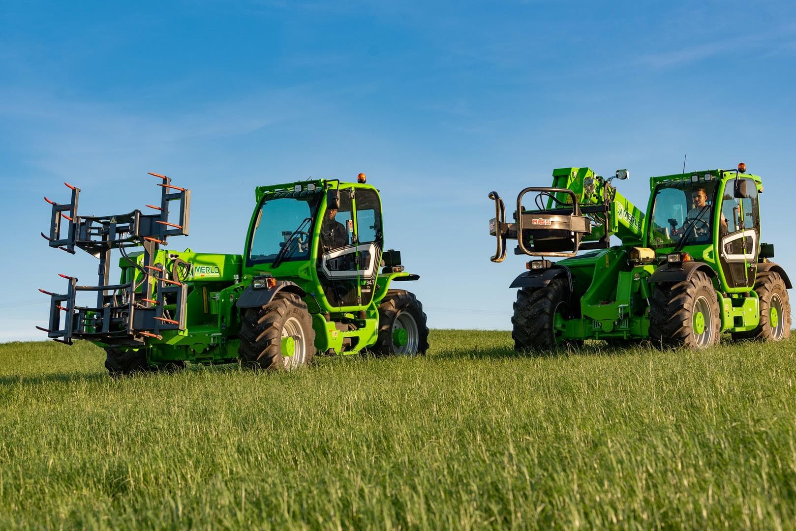 Twee Merlo Multifarmer 34.9 starre verreikers met balenklemmen op grasland