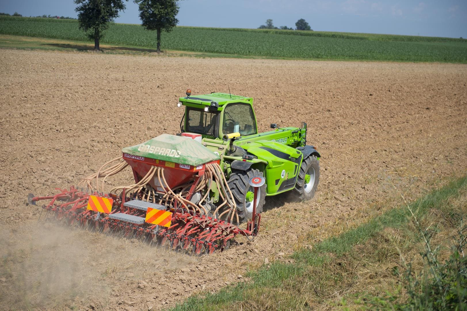 Merlo Multifarmer 34.9 starre verreiker met zaaimachine op akker