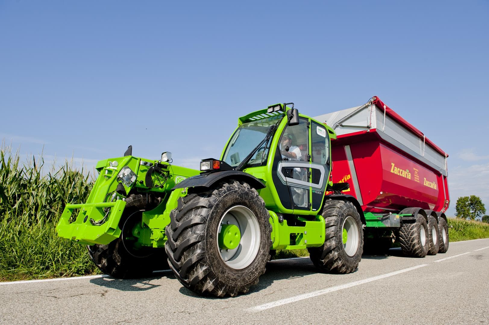 Merlo Multifarmer 40.9 starre verreiker met rode aanhangwagen op de weg