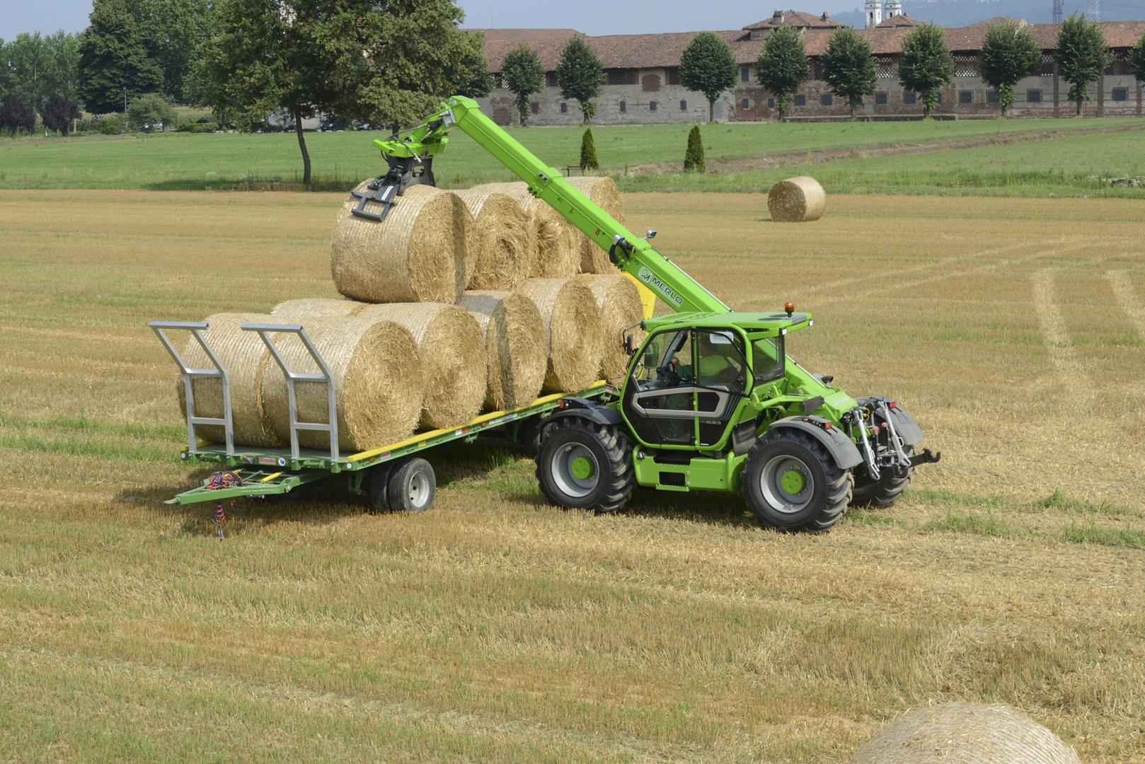 Merlo Multifarmer 40.9 starre verreiker laadt hooibalen op een aanhanger