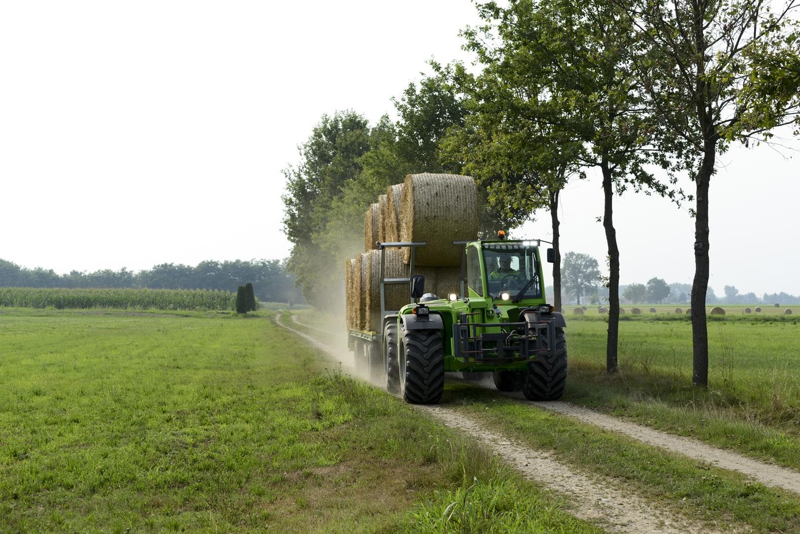 Merlo Multifarmer 40.9 starre verreiker vervoert hooibalen langs landweg