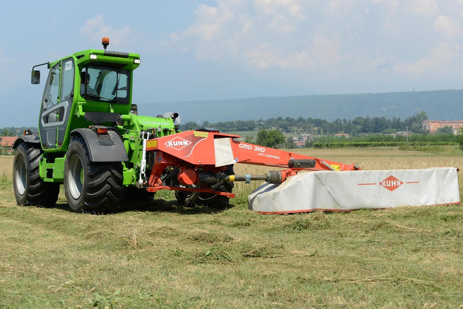 Merlo Multifarmer 40.7 starre verreiker met een maaimachine in het veld