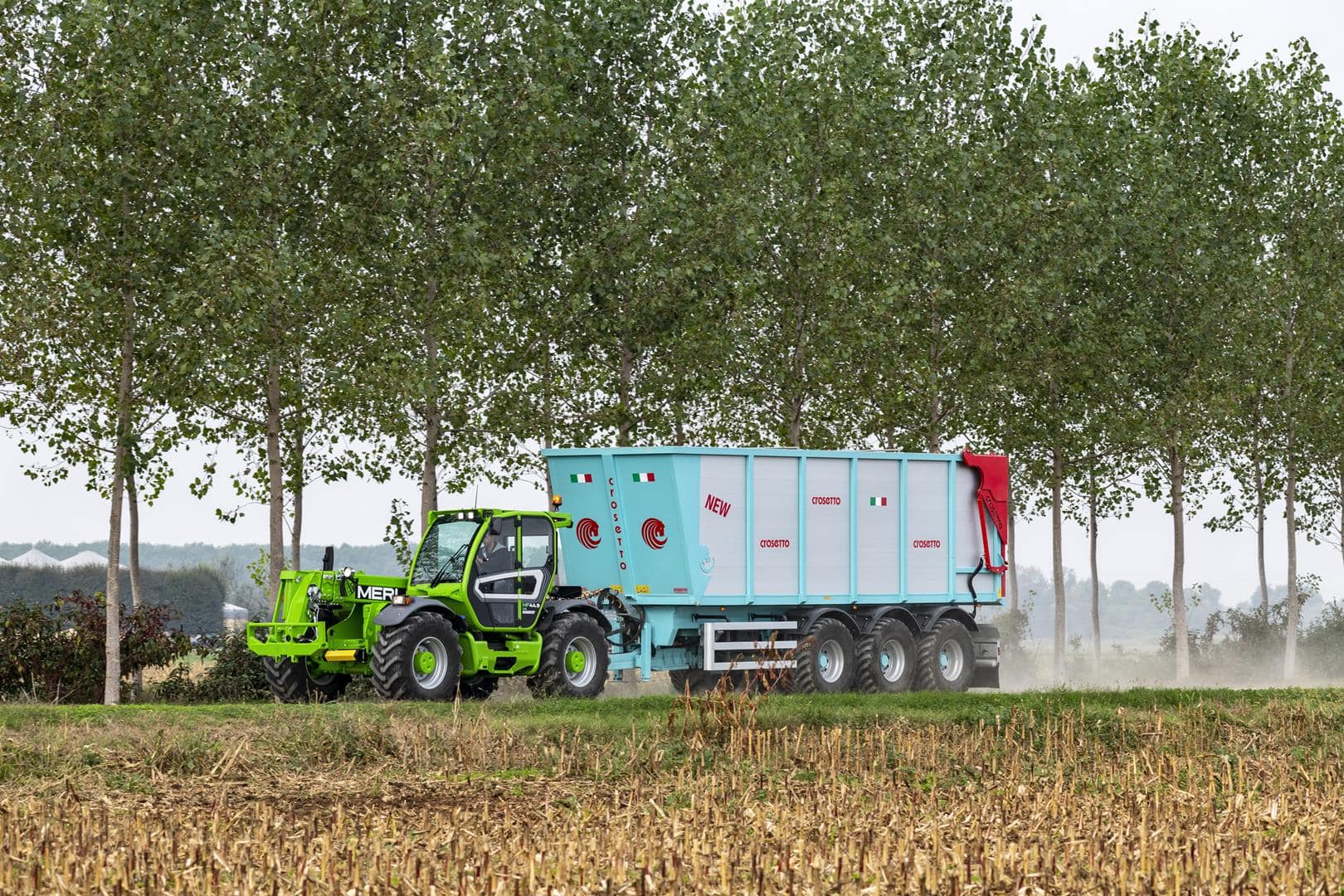 Merlo Multifarmer 44.9 starre verreiker met landbouwoplegger op veldweg