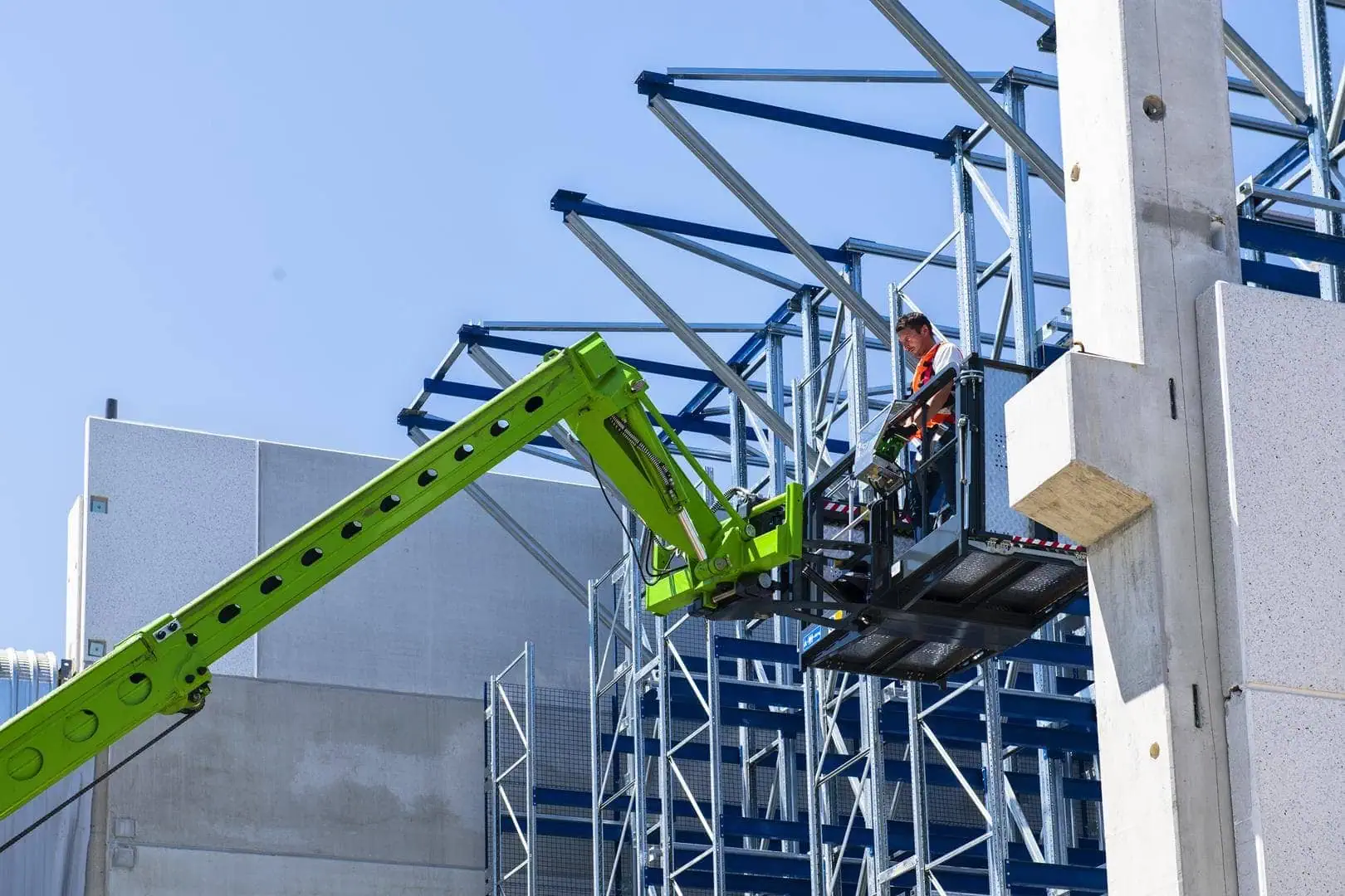 Merlo ROTO 50.26 verreiker arm met uitschuifbare werkkooi bij staalconstructie.