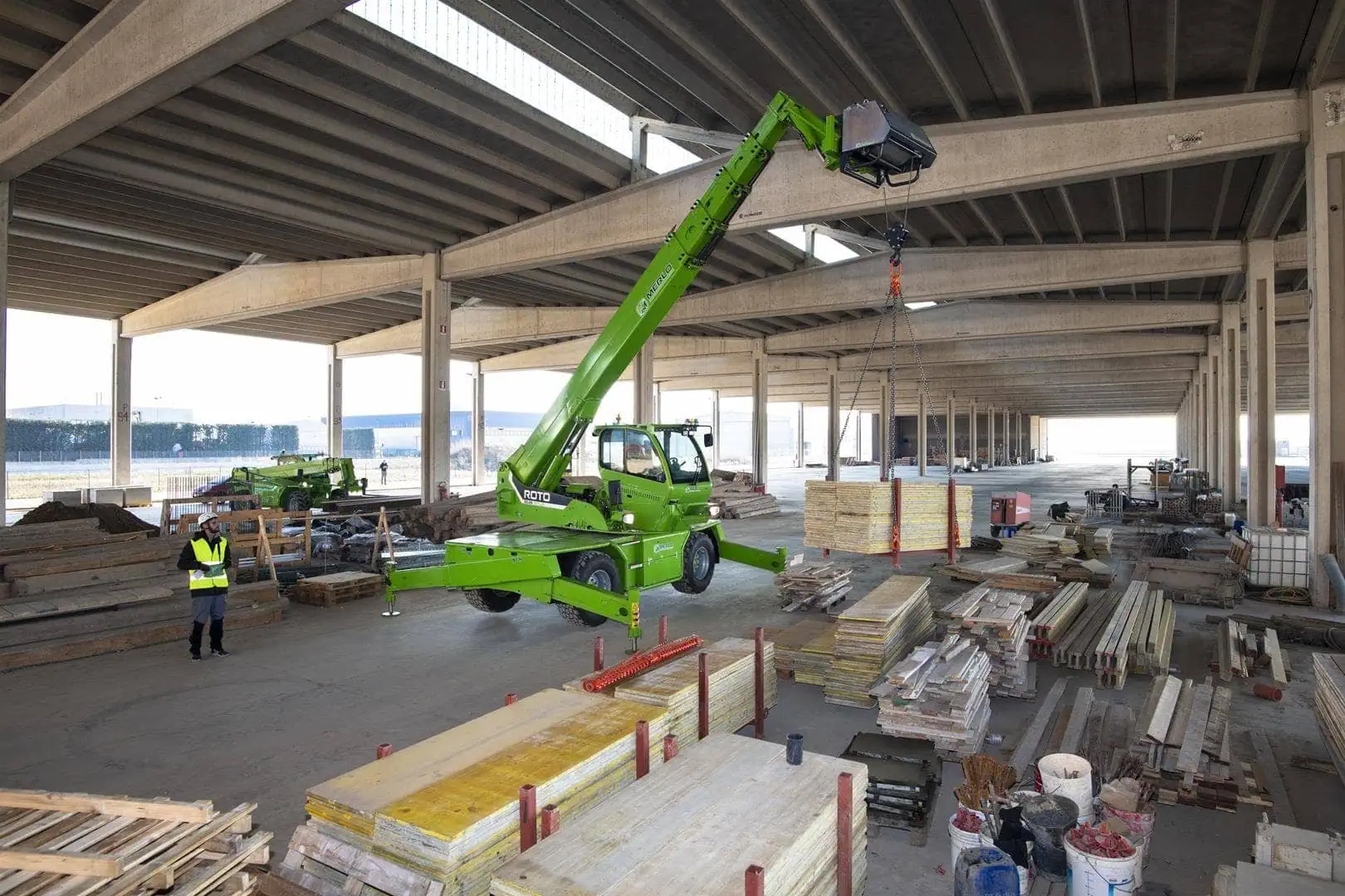 Merlo ROTO 50.26 roterende verreiker met hydraulische lier gebruikt binnen in een bouwdepot.