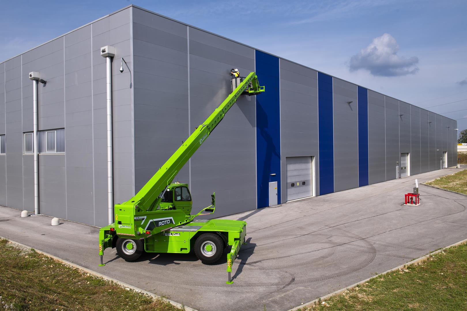 Merlo ROTO 70.28S roterende verreiker met werkkooi voor een grote loods.