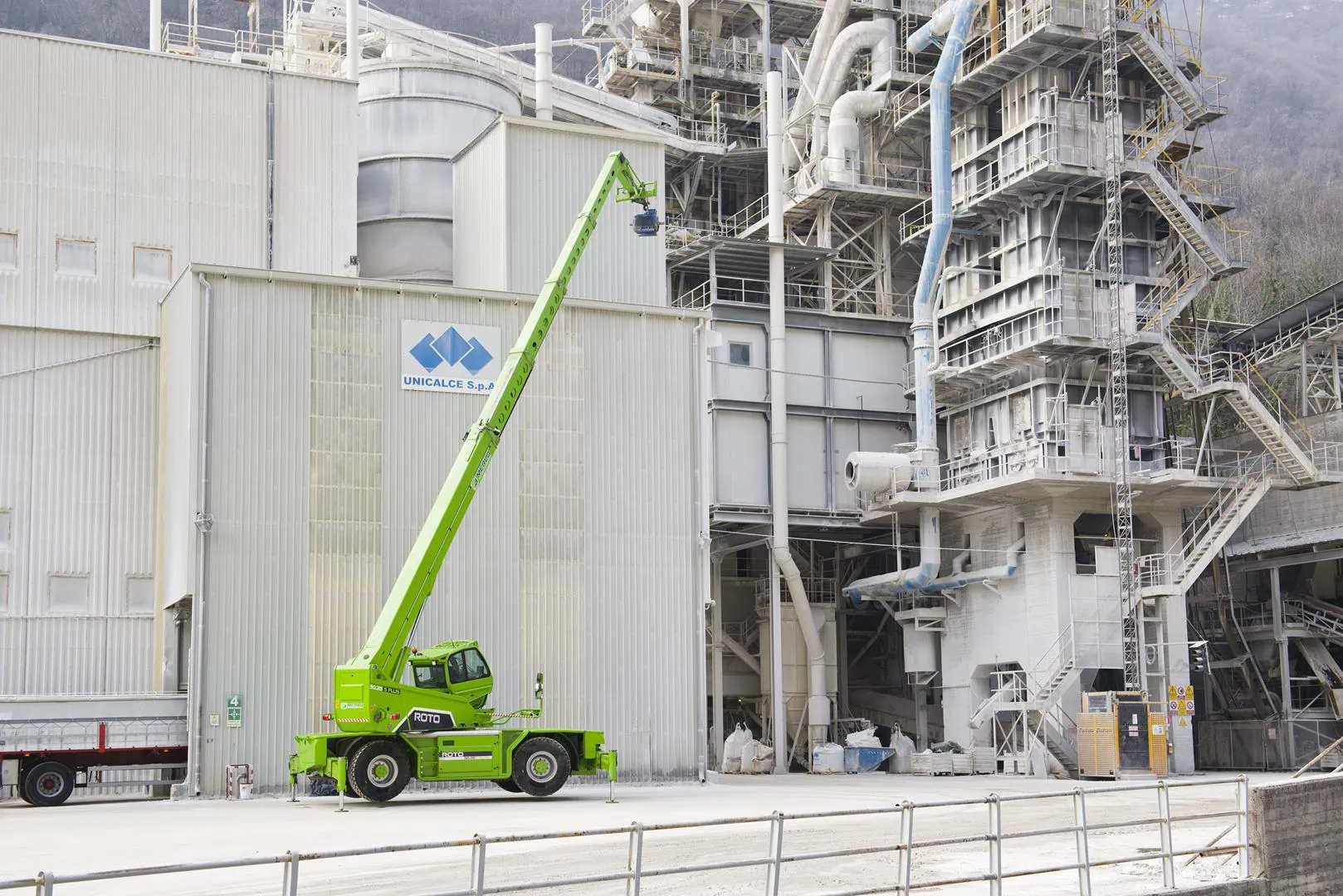 Merlo ROTO 70.28S roterende verreiker met volledig uitgeschoven mast bij industriële fabriek