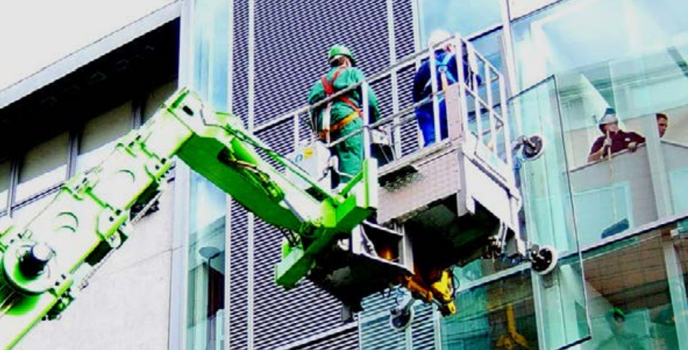 Merlo verreiker met werkbak met zuiger vervoert een raam aan de buitenkant van een gebouw